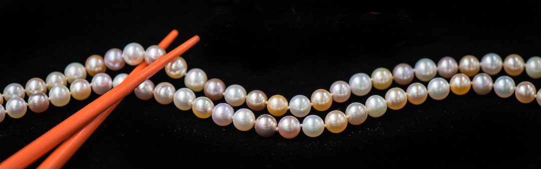 Pastel pearls held by orange chopsticks